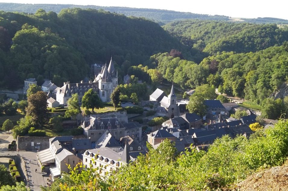 Panoramisch uitzicht op Durbuy met stenen huizen en beboste heuvels